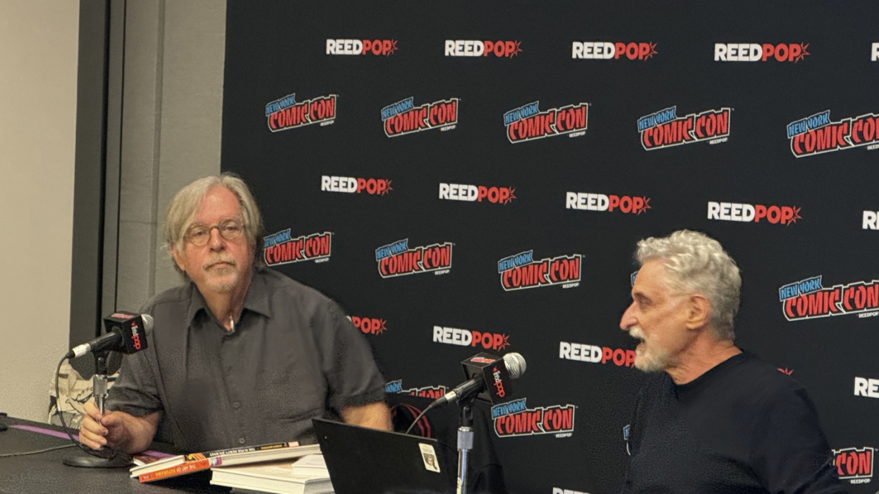 Matt Groening and Patrick McDonell sitting behind two microphones and talking in front of a live audience.